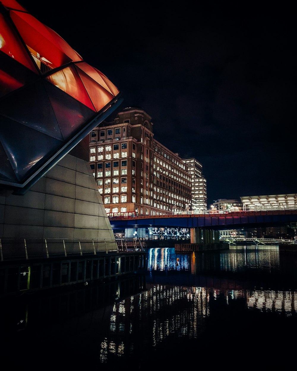 high rise building near body of water during night time