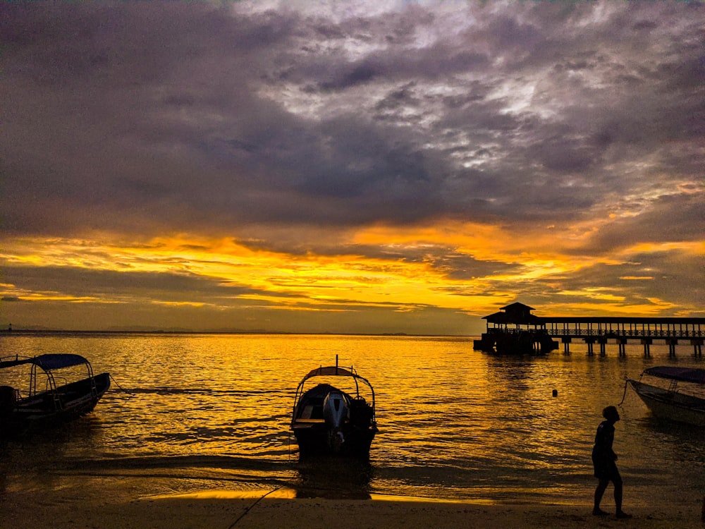 silhouette of boat on sea during sunset