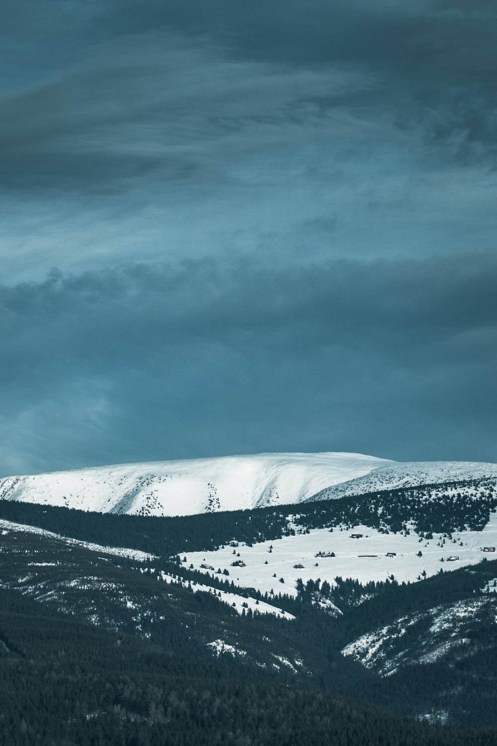 Schneebedeckter Berg tagsüber unter bewölktem Himmel