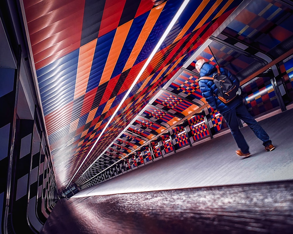 a man in a blue jacket is walking through a colorful room