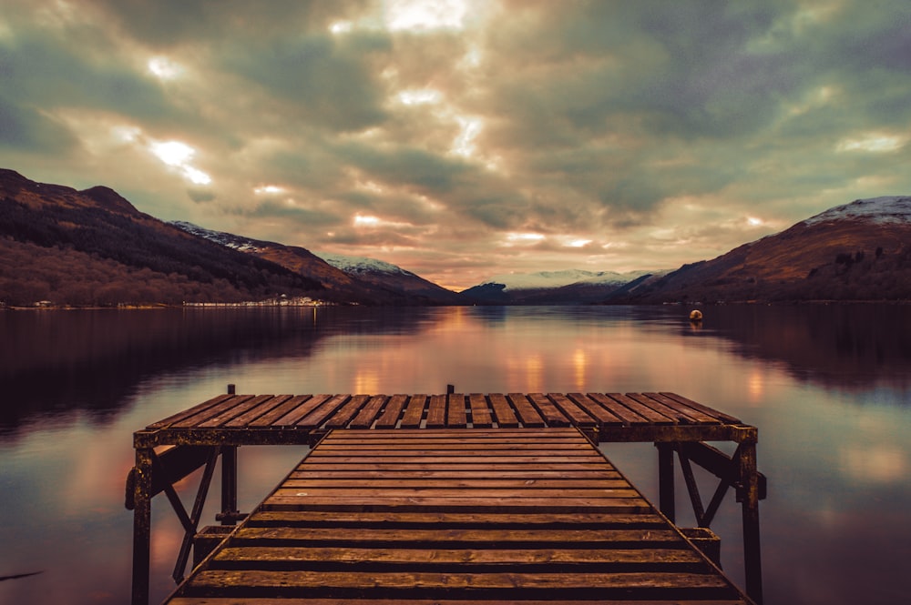 brown wooden dock on lake during daytime