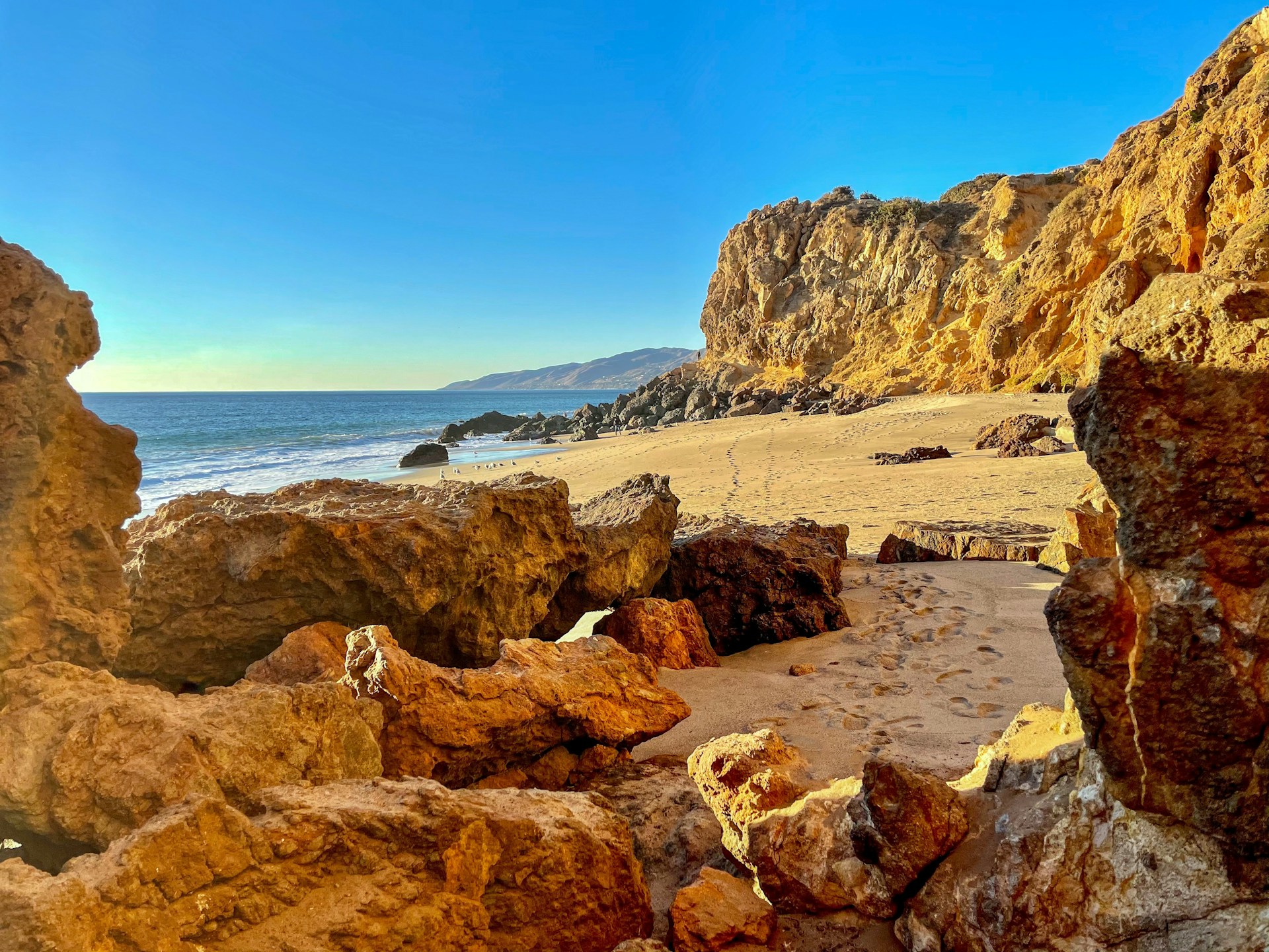 brown rock formation near body of water during daytime