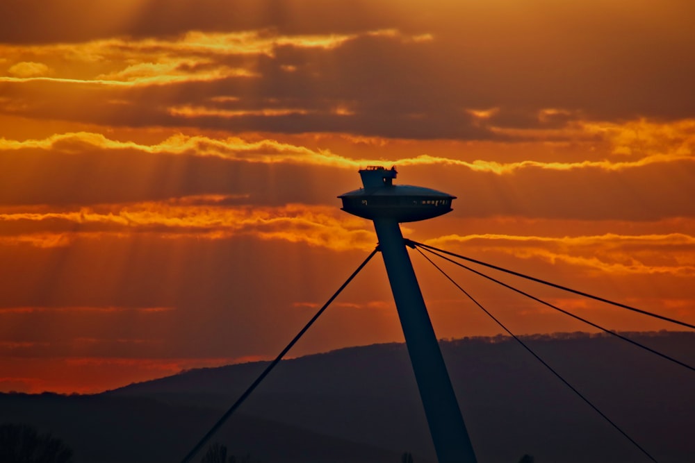 silhouette of a person on a tower during sunset