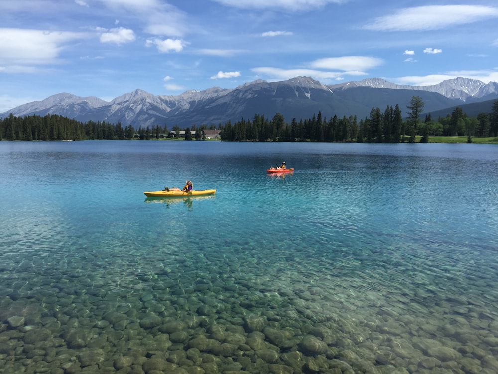 2 people riding kayak on body of water during daytime