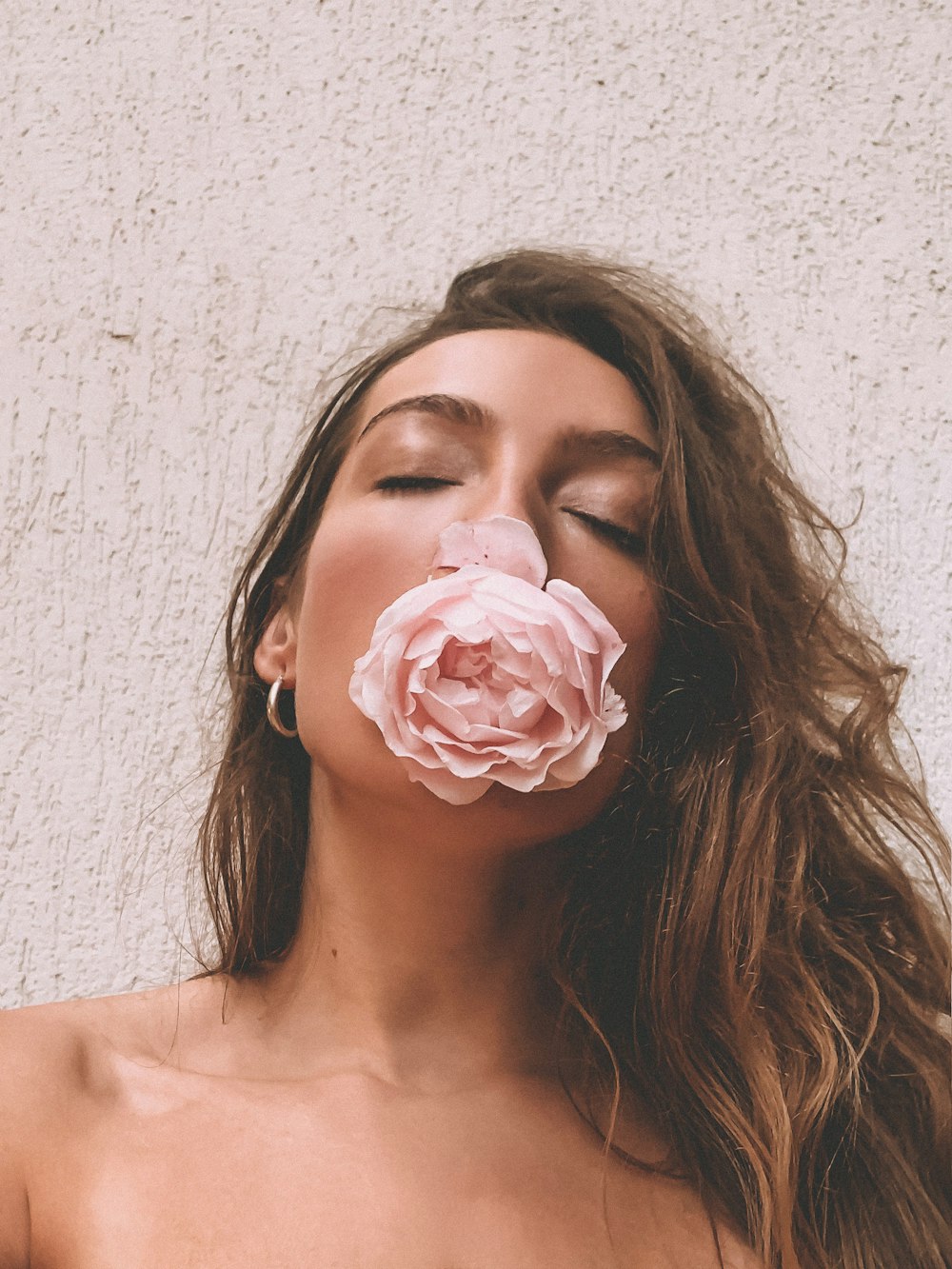 mujer con rosa rosa en la boca