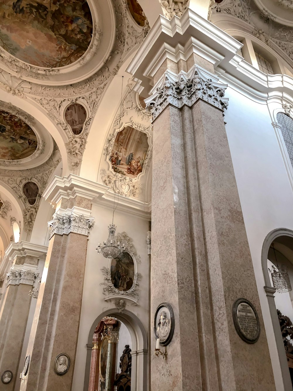 a tall pillar in a building with paintings on the walls