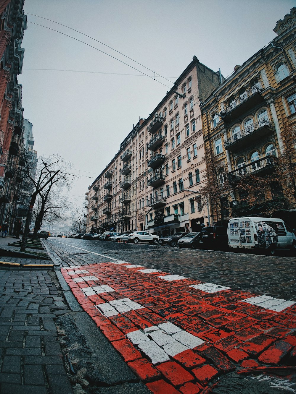 cars parked on side of the road near buildings during daytime