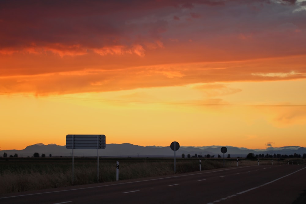 Camión blanco y negro en la carretera durante la puesta del sol