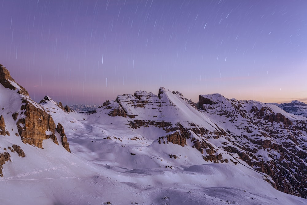 montanha coberta de neve sob o céu azul durante o dia