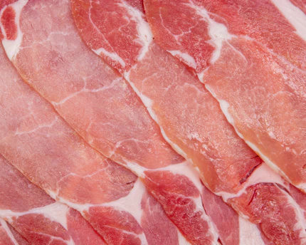 raw bacon on white surface