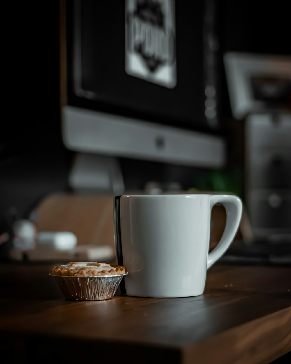 white ceramic mug beside brown round biscuit