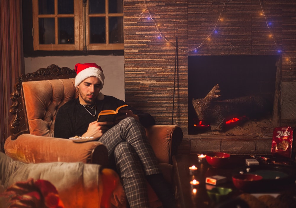 man in black jacket sitting on brown sofa