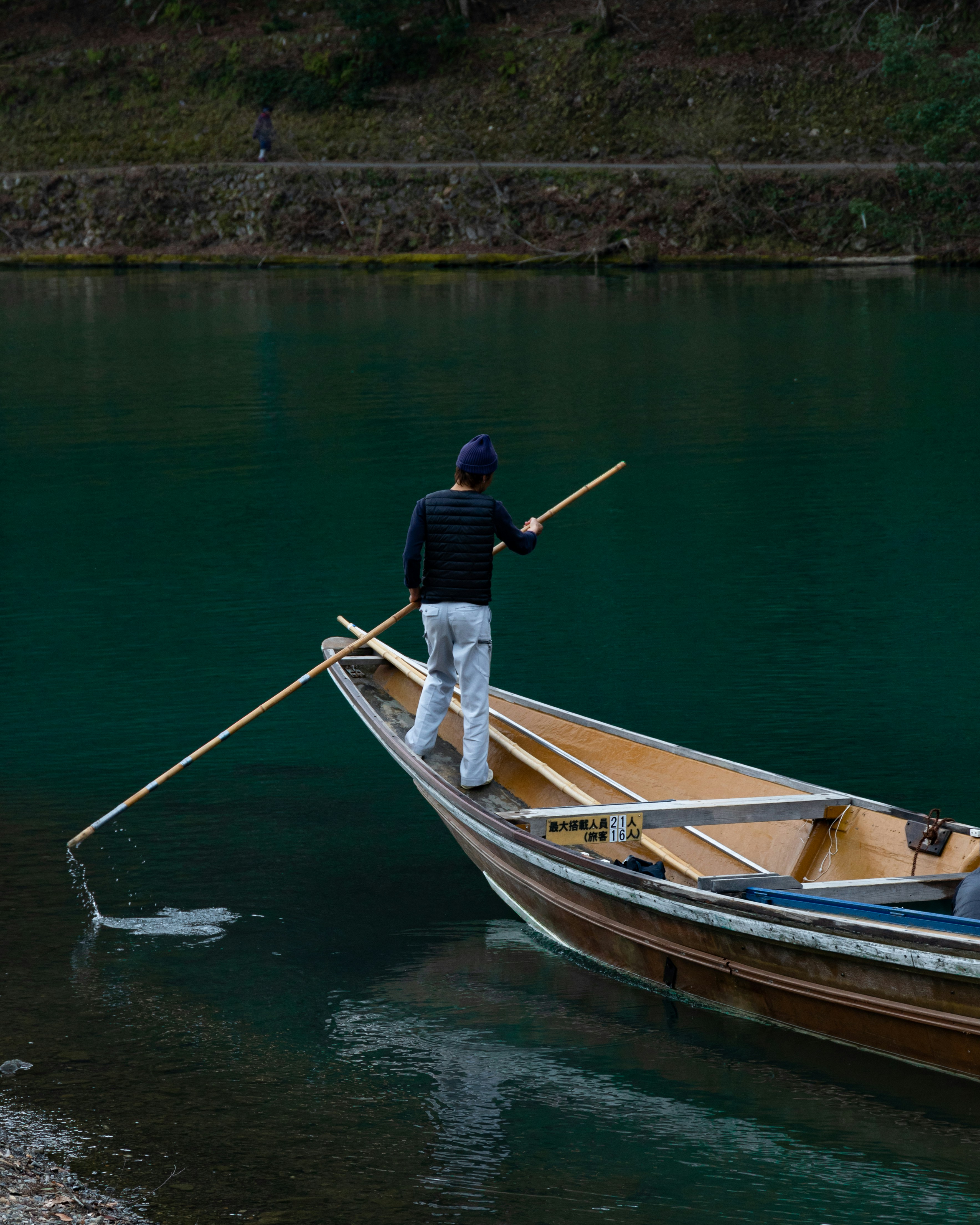 man in blue shirt and black shorts riding on brown boat