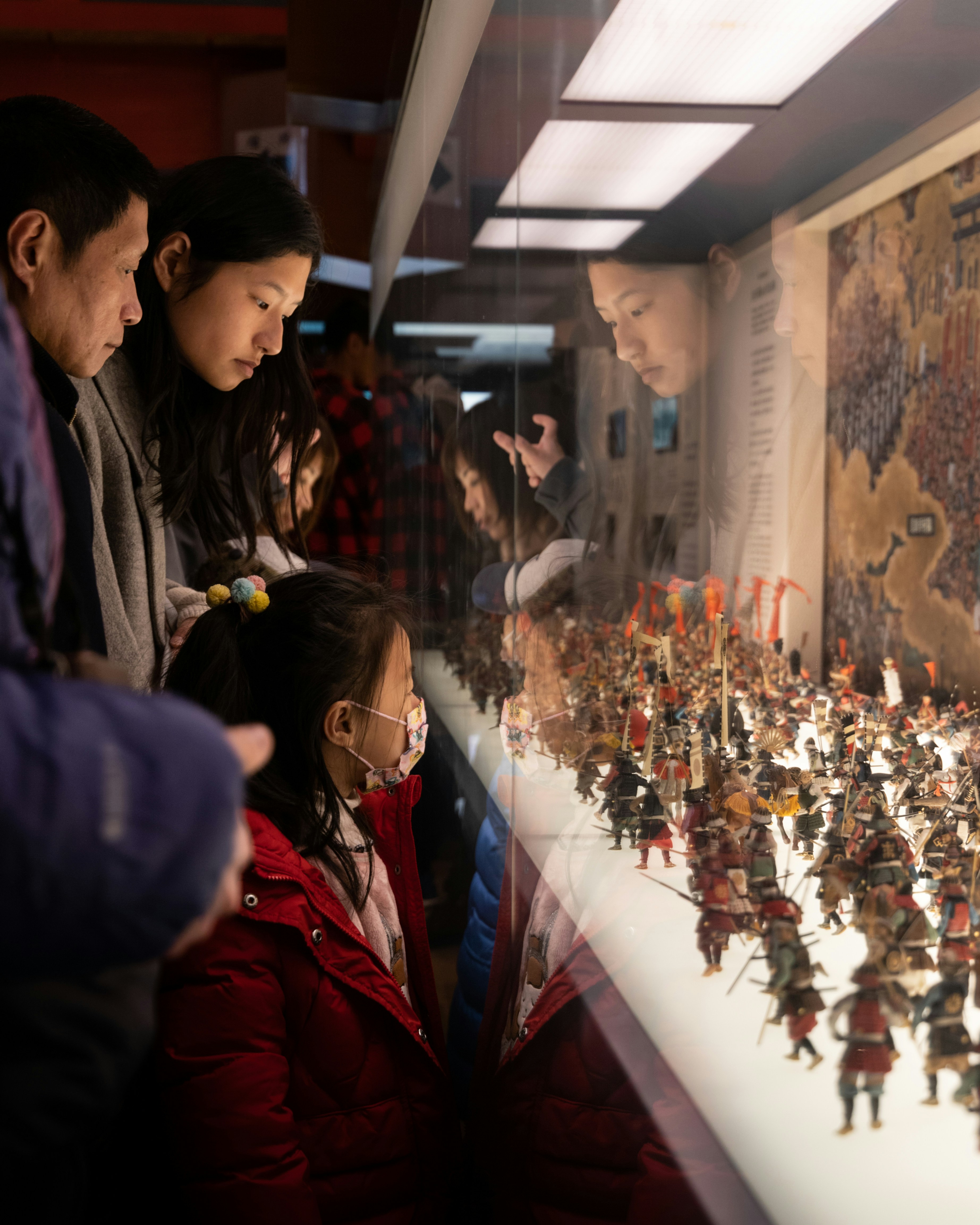 man in black jacket standing beside woman in red coat