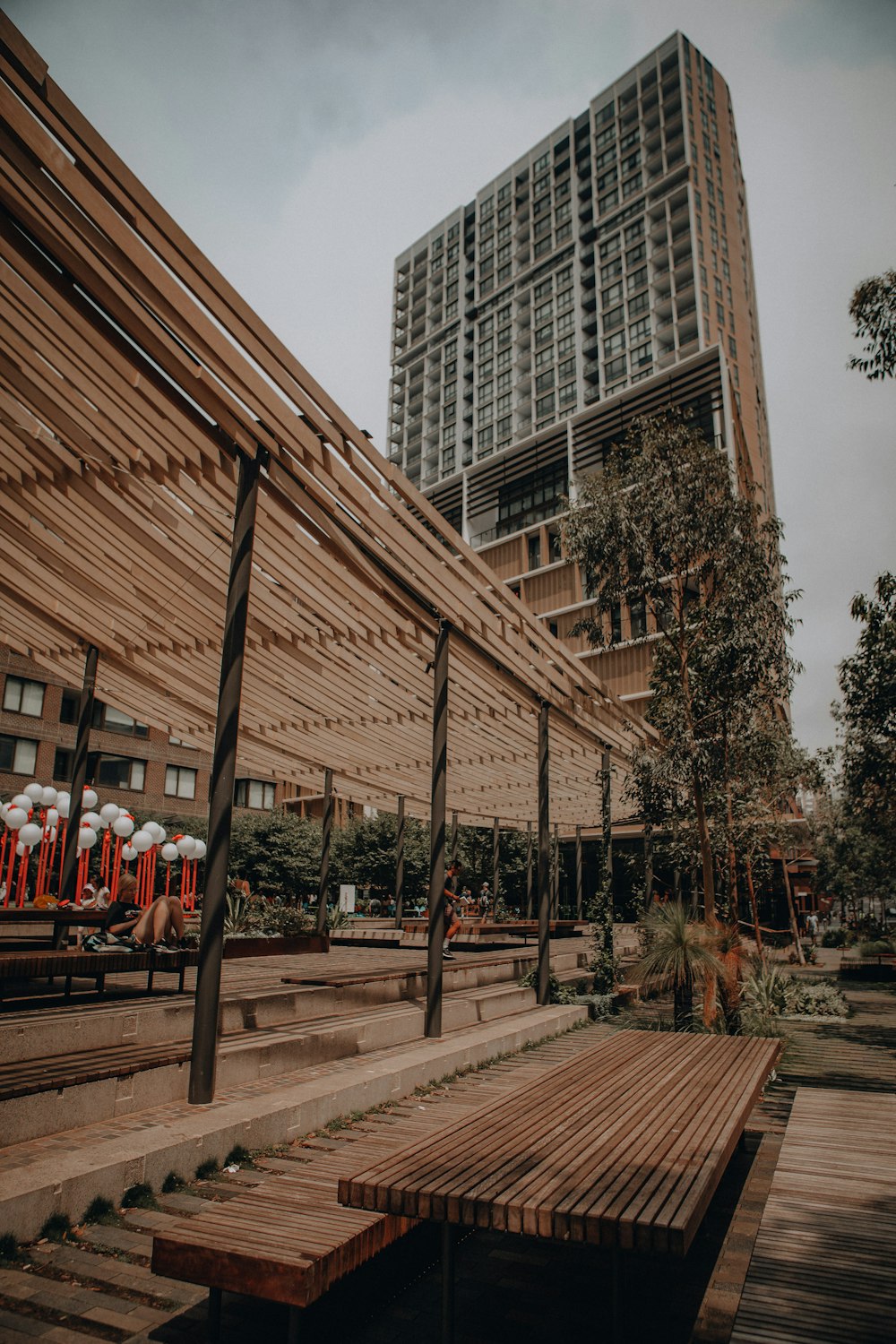 people standing near brown wooden bench during daytime