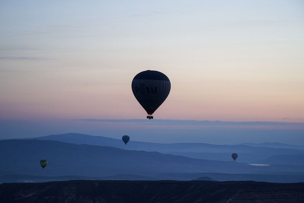 hot air balloon flying over the clouds during sunset