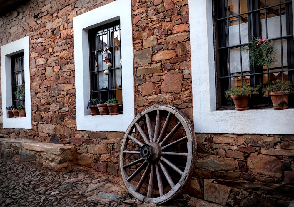 black wooden wheel on brown brick wall