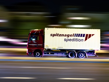 red and white truck on road during daytime