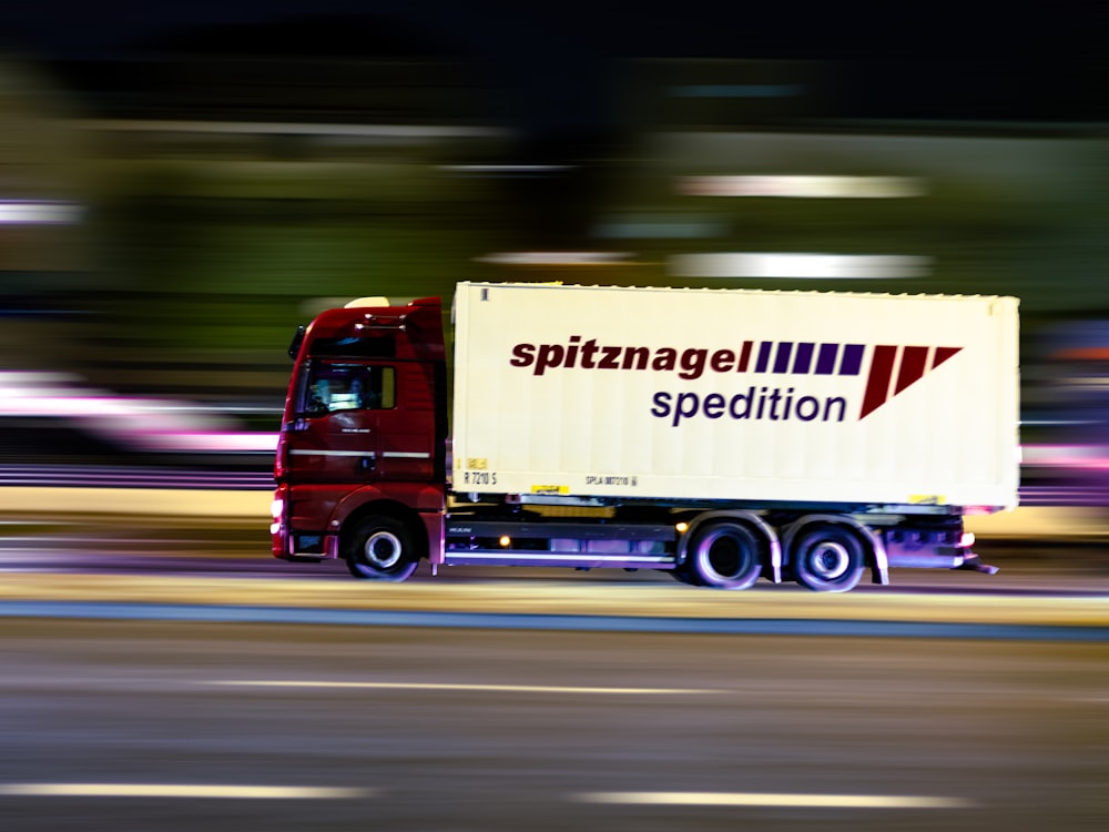 red and white truck on road during daytime