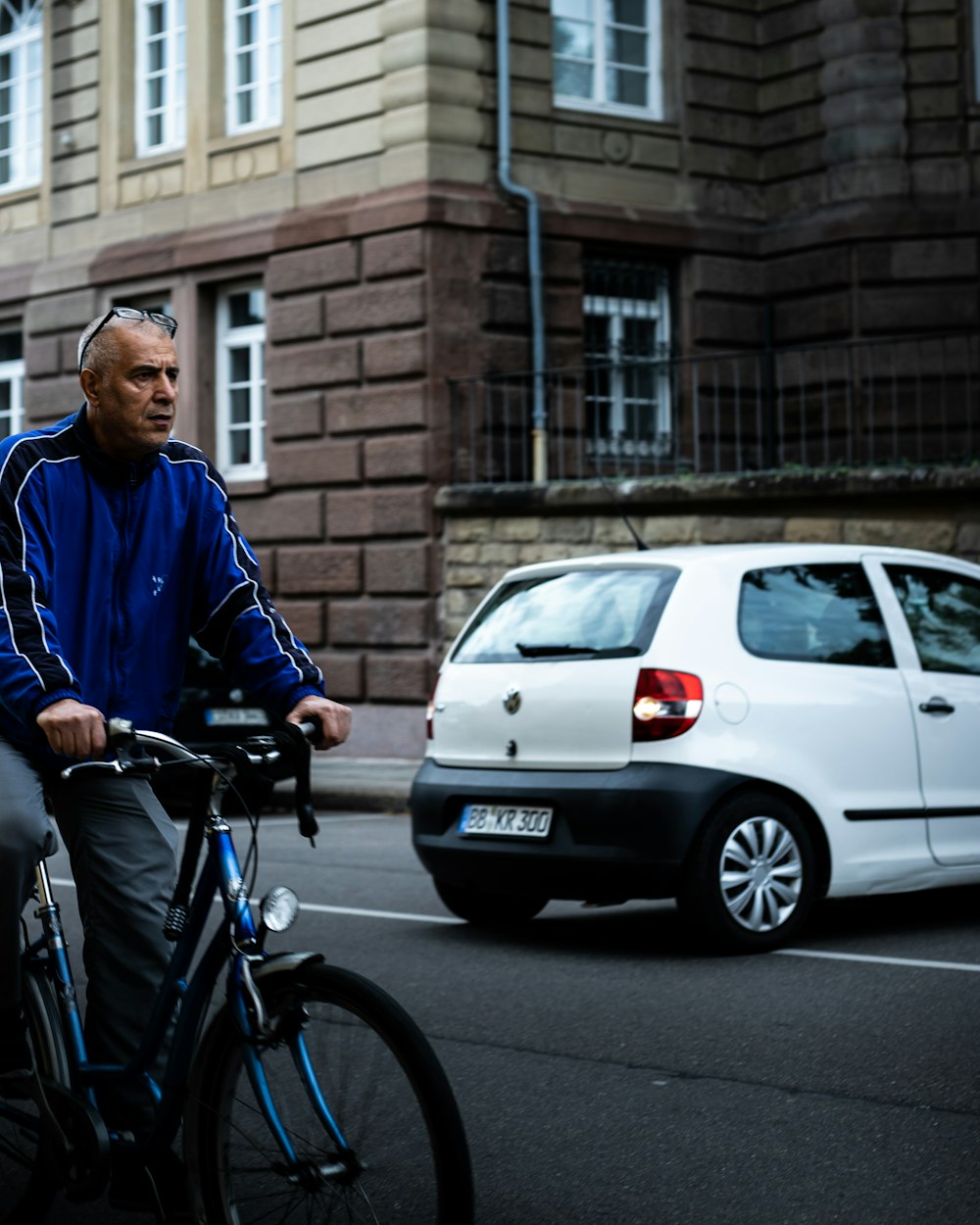 man in blue jacket riding on bicycle