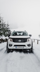 gray nissan suv on snow covered road during daytime