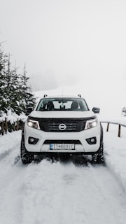 gray nissan suv on snow covered road during daytime