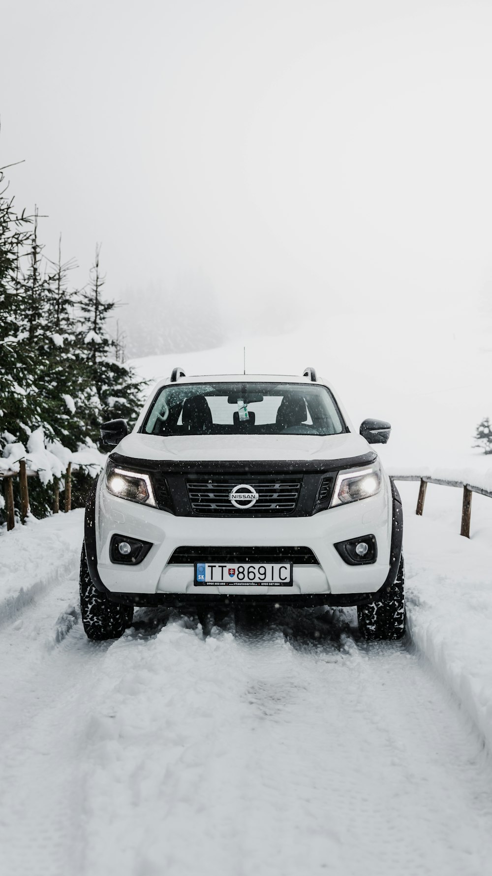 SUV Nissan gris en carretera cubierta de nieve durante el día