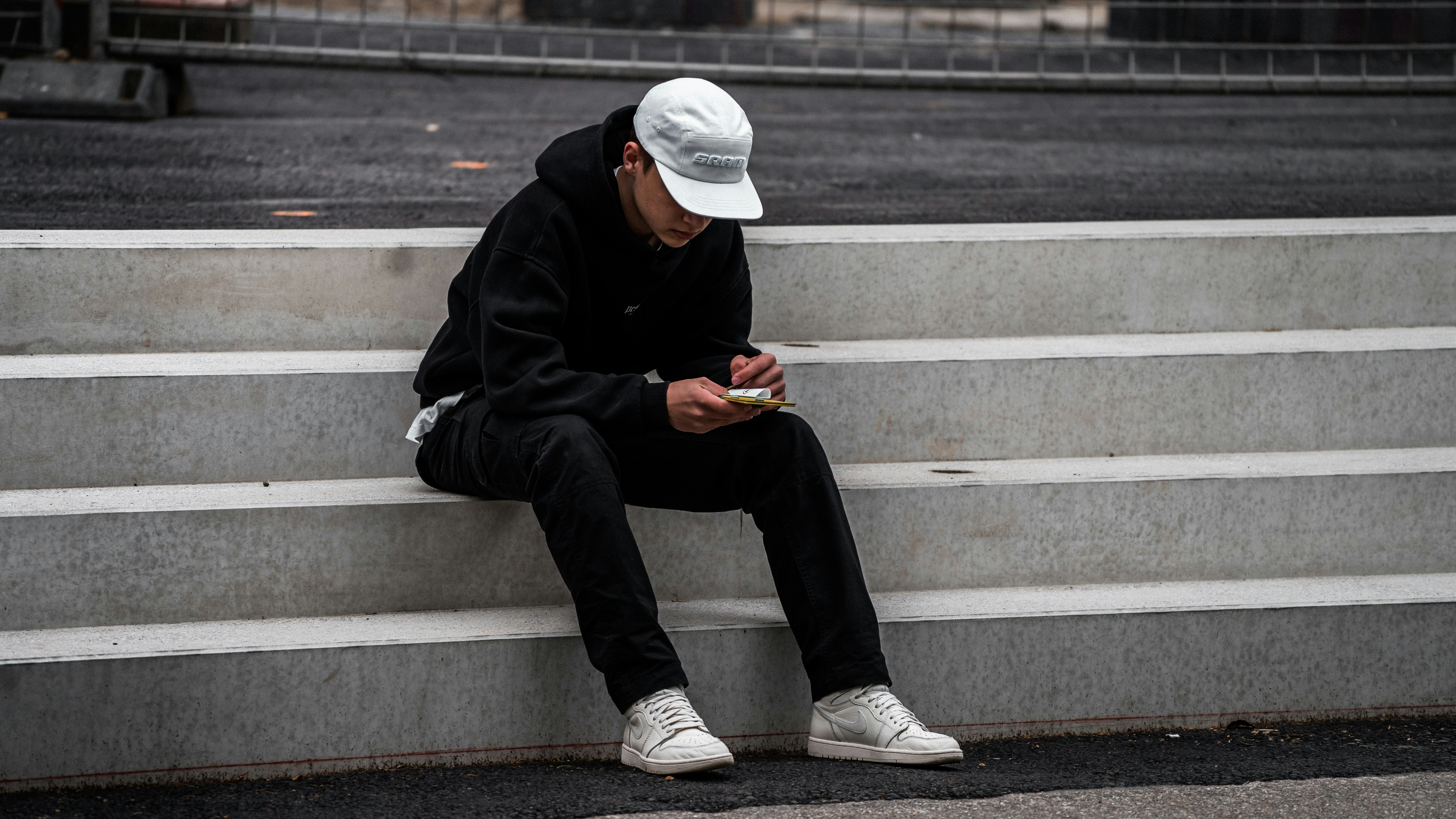 man in black hoodie sitting on stairs