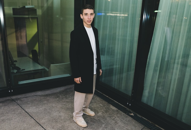 mulher em blazer preto perto de parede de vidro