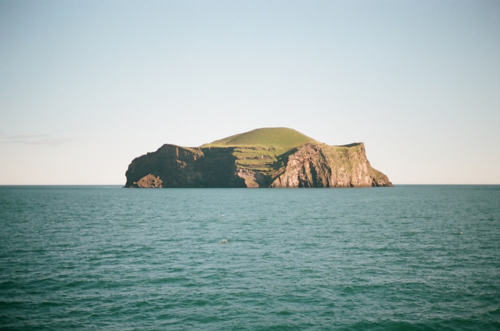 green island on blue sea under white sky during daytime