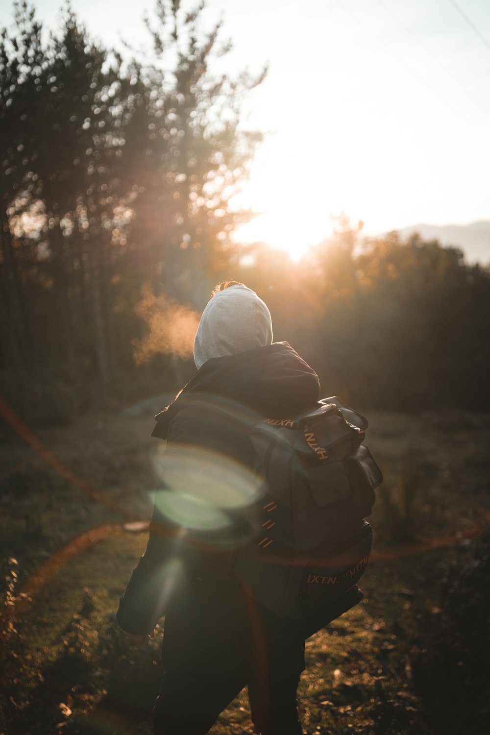 person in white hoodie and black backpack