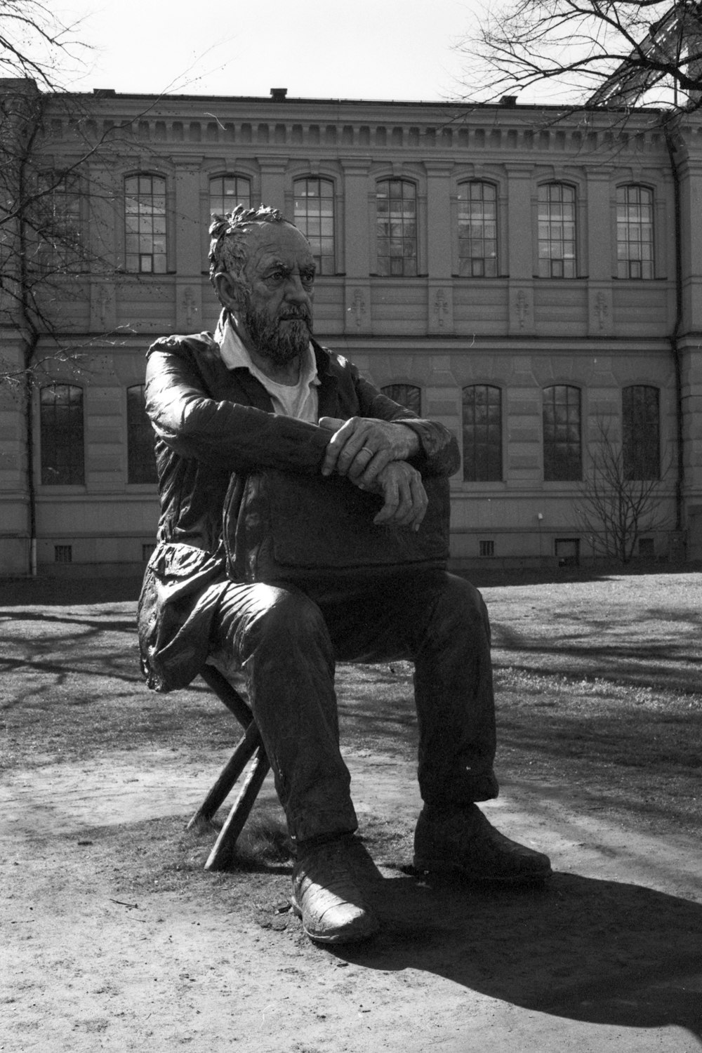 man in black jacket and pants sitting on chair