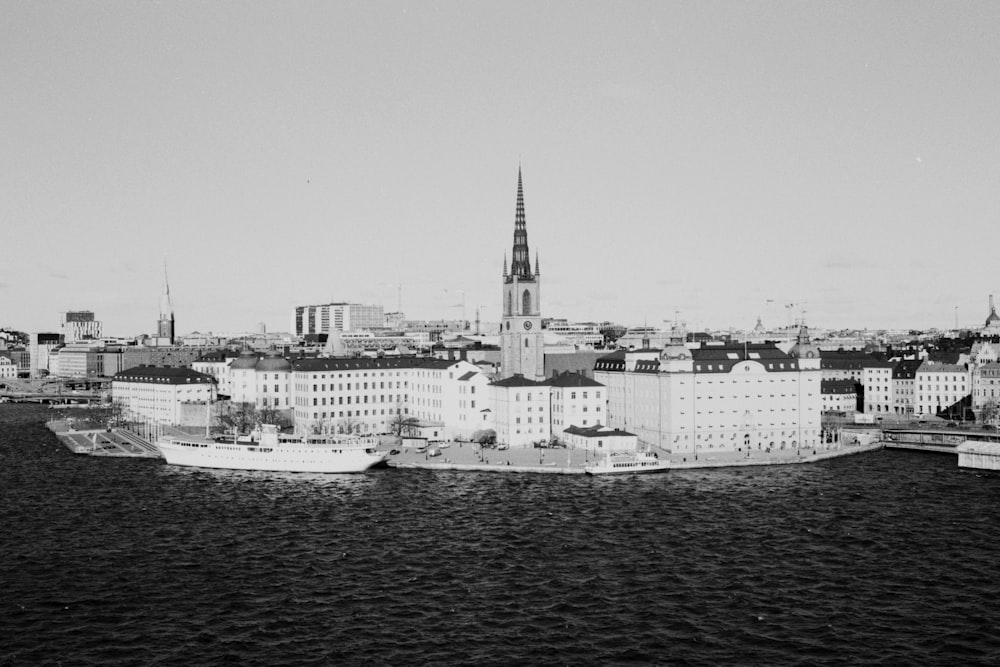 grayscale photo of city buildings near body of water