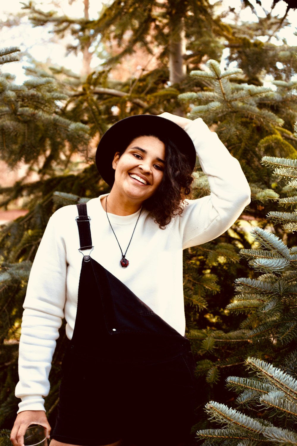 woman in black and white long sleeve shirt standing near green tree during daytime