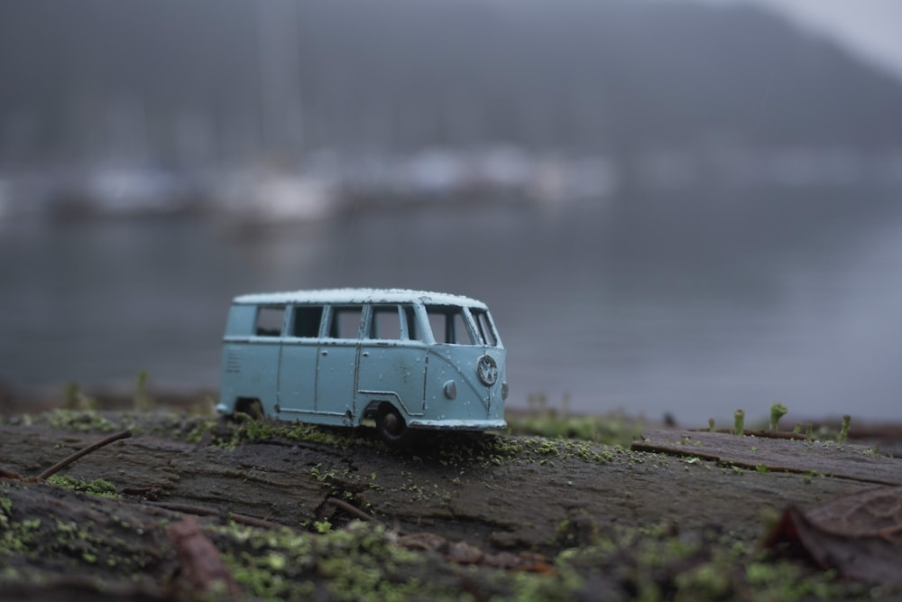 blue and white volkswagen t-1 on brown soil near body of water during daytime
