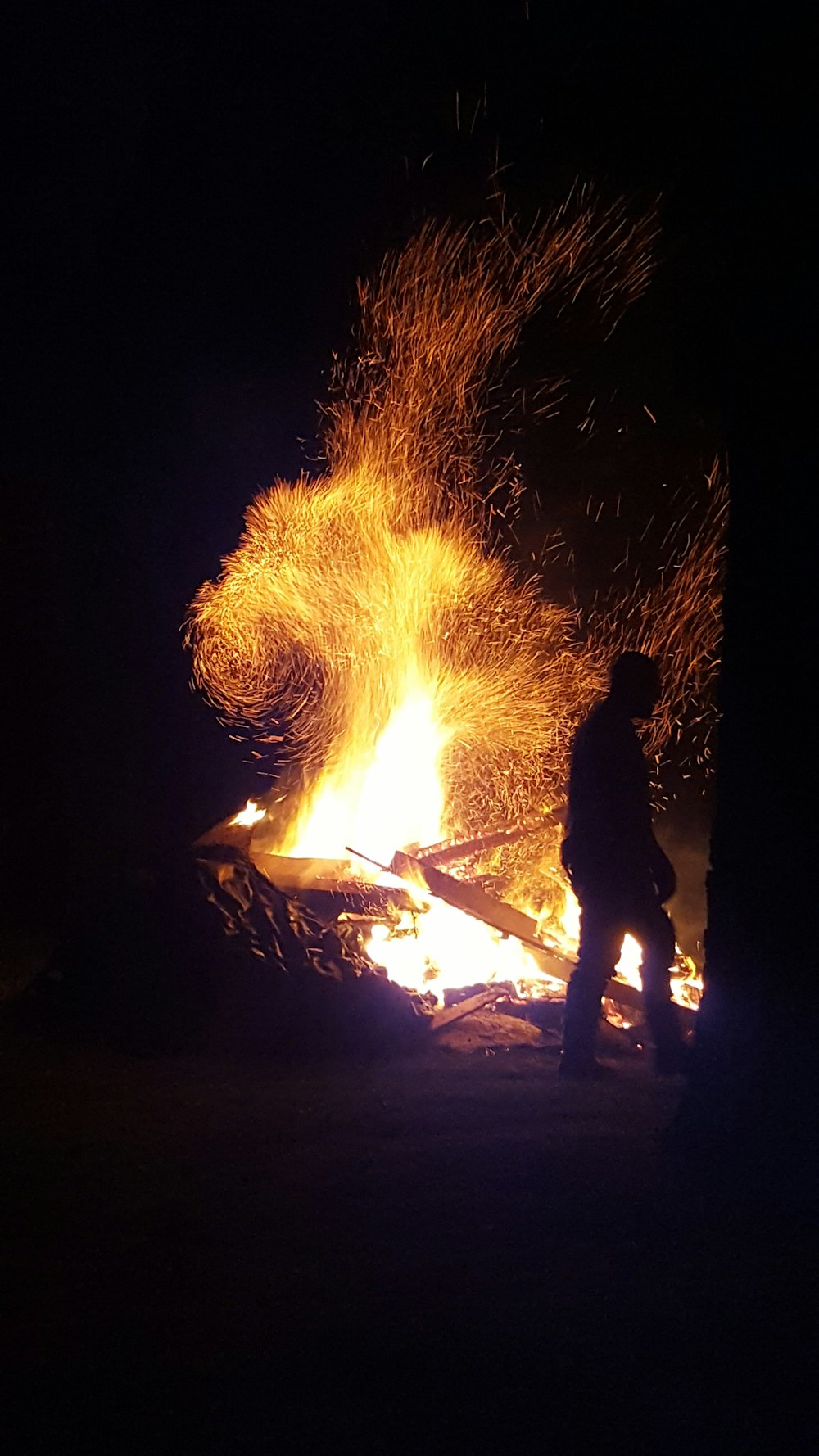 man standing near bonfire during night time