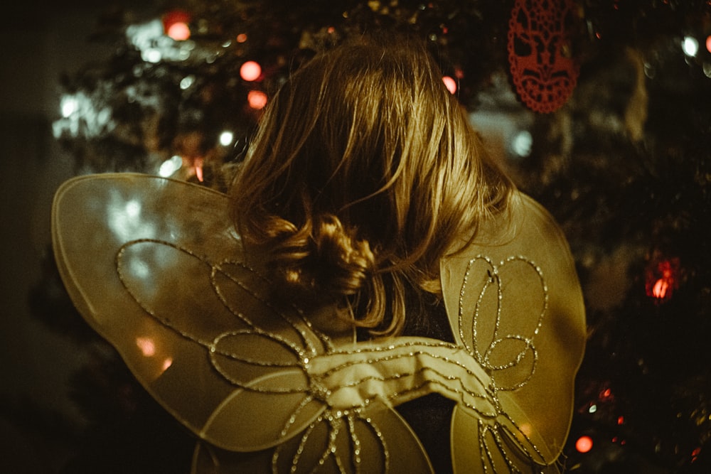 woman in brown long sleeve shirt with gold heart balloon on her shoulder