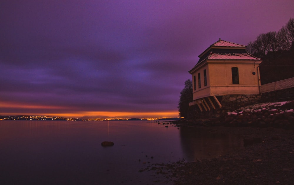 white and brown concrete building near body of water during night time