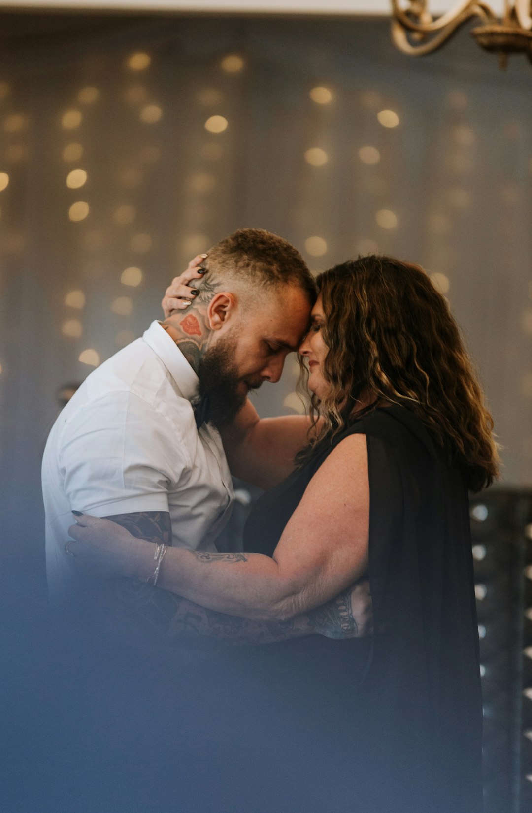 man in white dress shirt kissing woman in black sleeveless dress