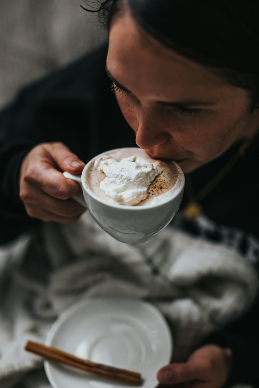 man in black shirt holding white ceramic mug with brown liquid