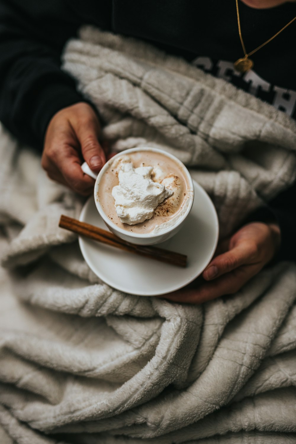 person holding white ceramic cup with cappuccino