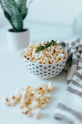 A close-up of a movie ticket and popcorn on a blue table