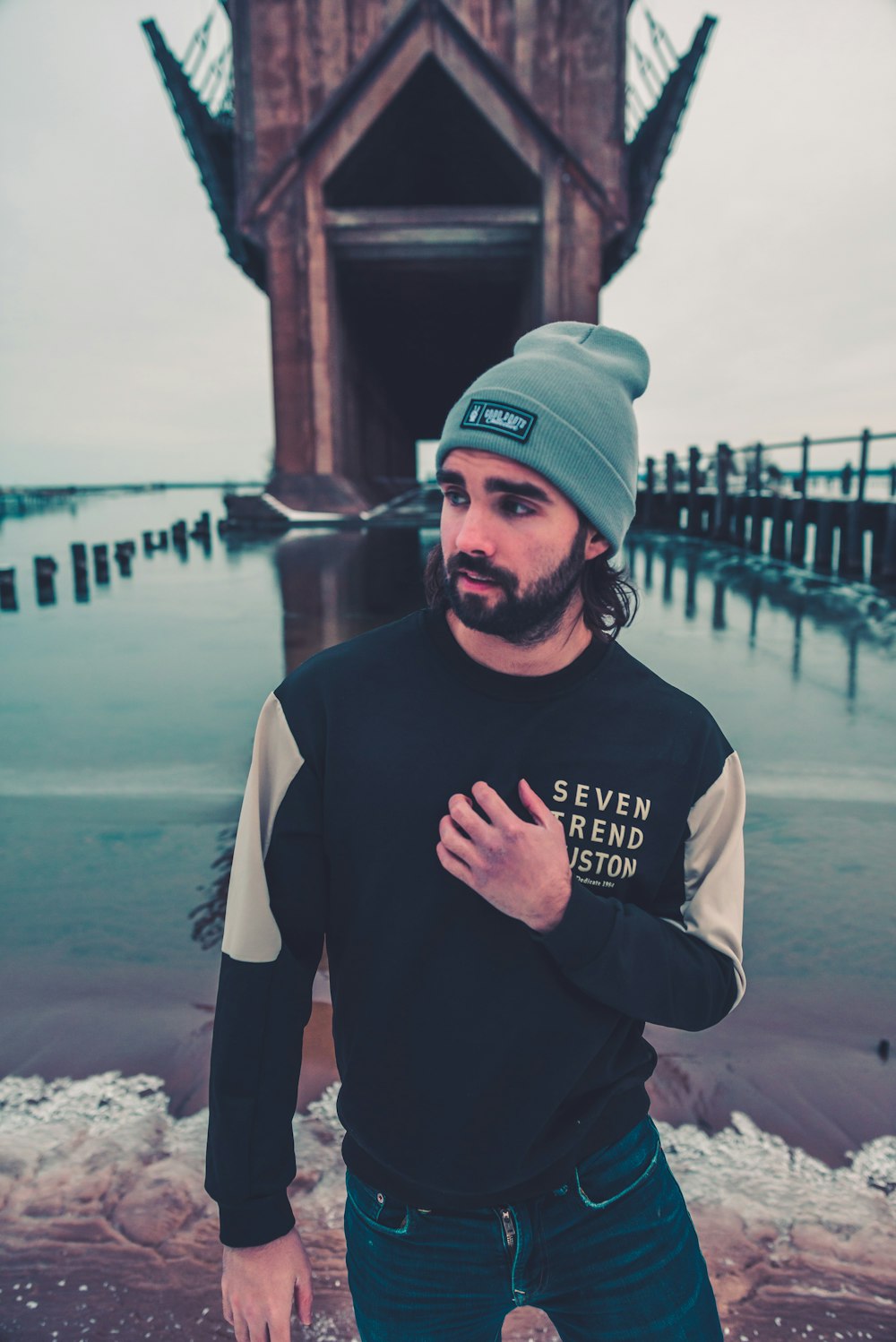 man in black crew neck long sleeve shirt and green fitted cap standing near body of near near near near