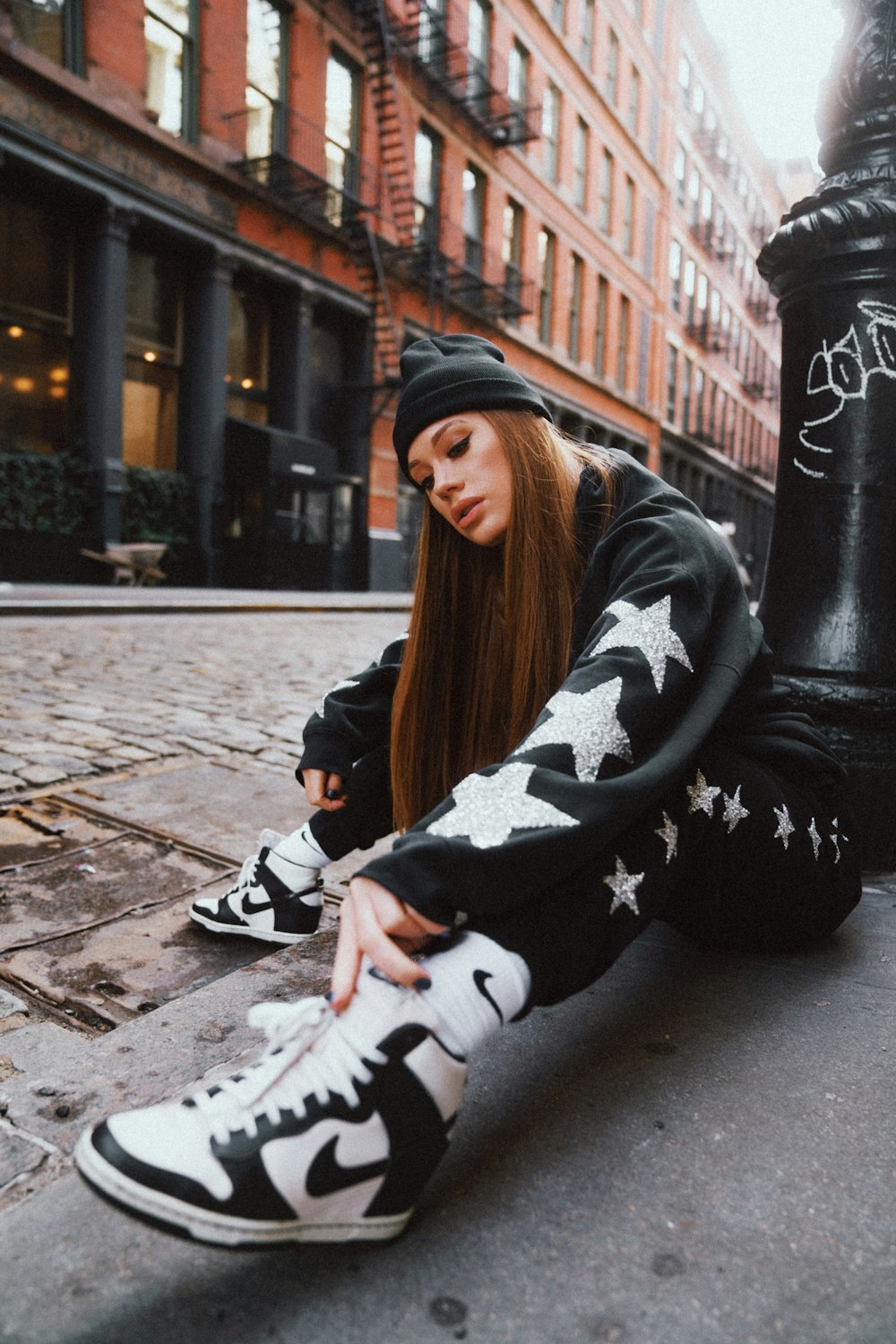 woman in black and white floral long sleeve shirt sitting on concrete bench during daytime