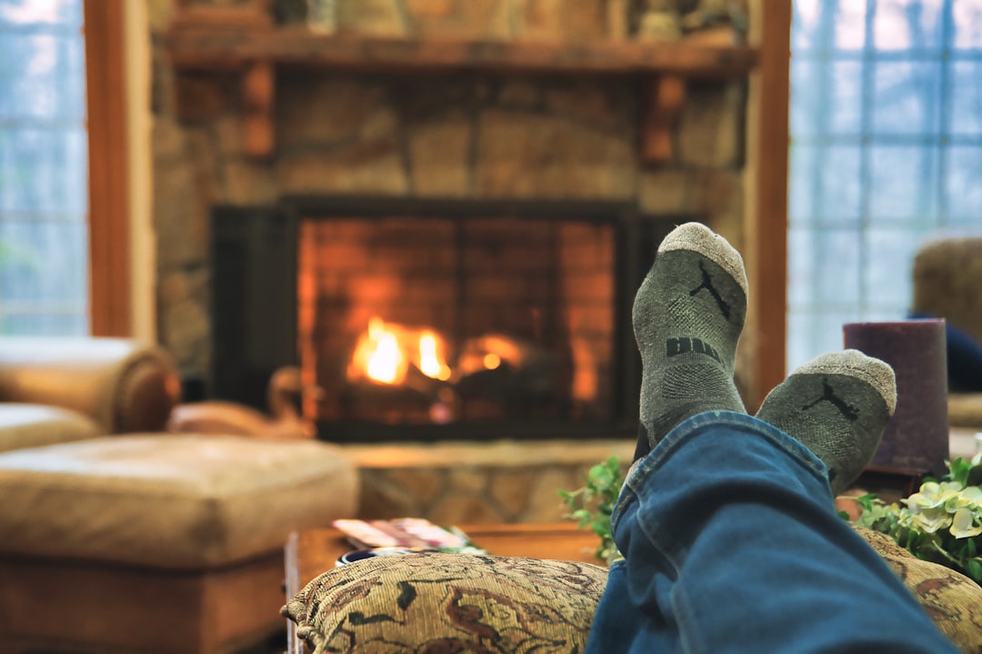 person in blue denim jeans and gray sock, A pic showing feet getting warm in a winter cabin.