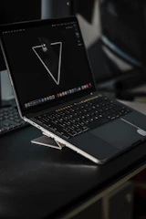 Dark-themed sleek laptop screen displaying a minimalist website interface with subtle gradients.