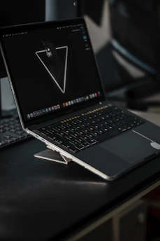 Dark-themed sleek laptop screen displaying a minimalist website interface with subtle gradients.