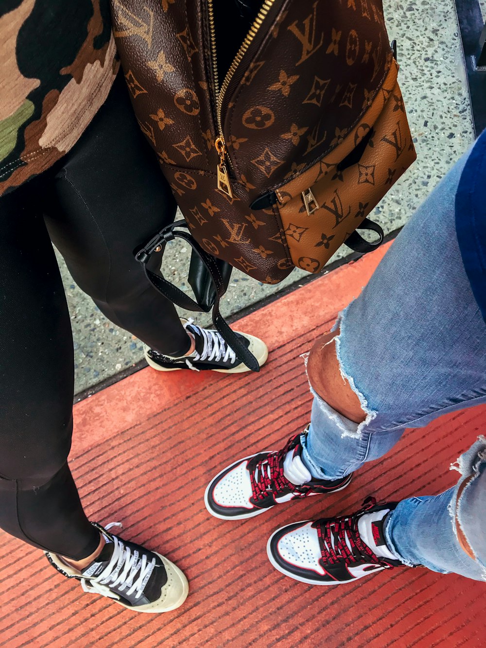 person in black pants and red and white sneakers