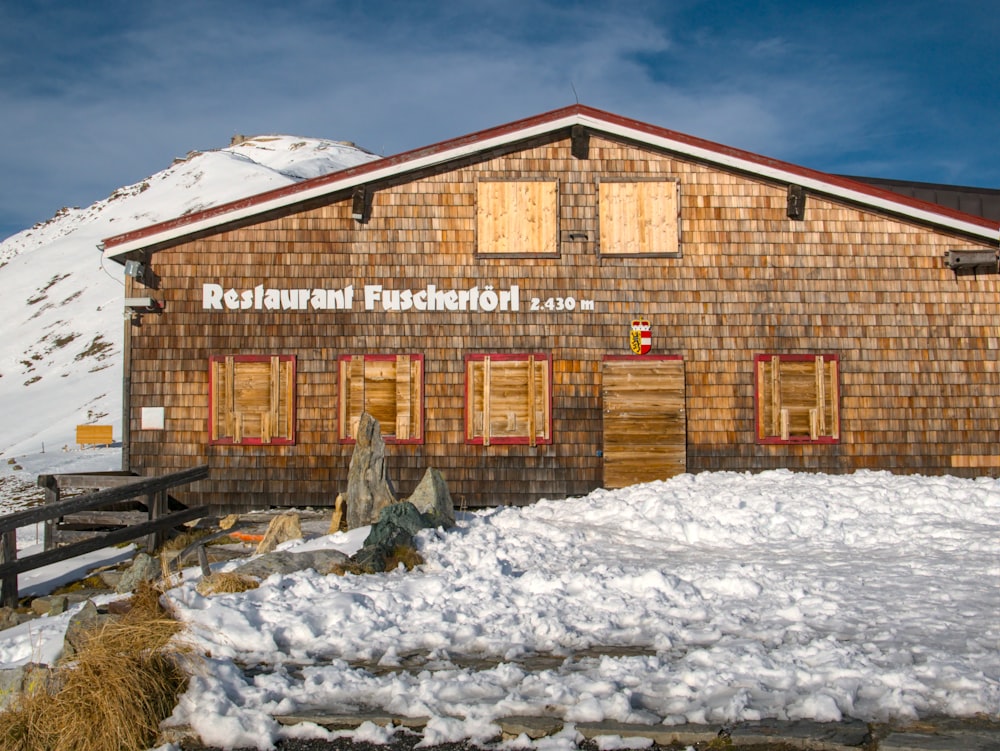 brown wooden house covered with snow during daytime