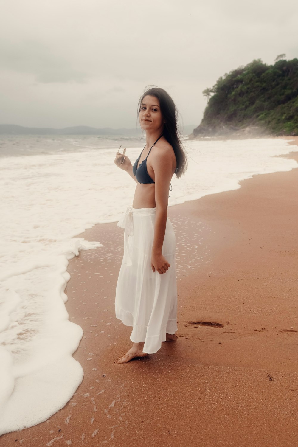 woman in white dress standing on beach during daytime